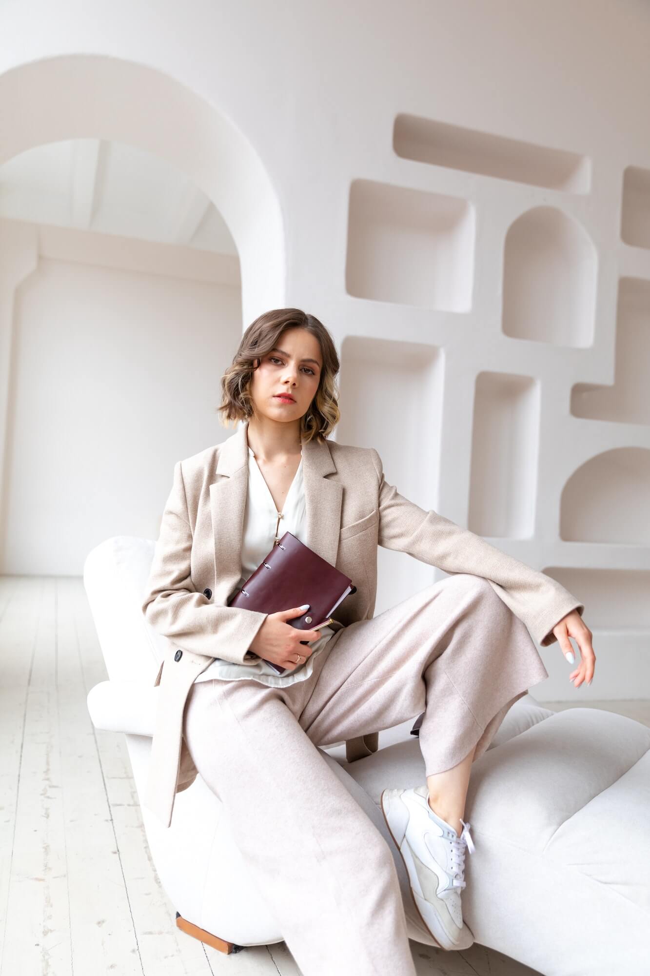 a-young-woman-coach-sits-on-the-white-armchair-with-business-dairy.jpg